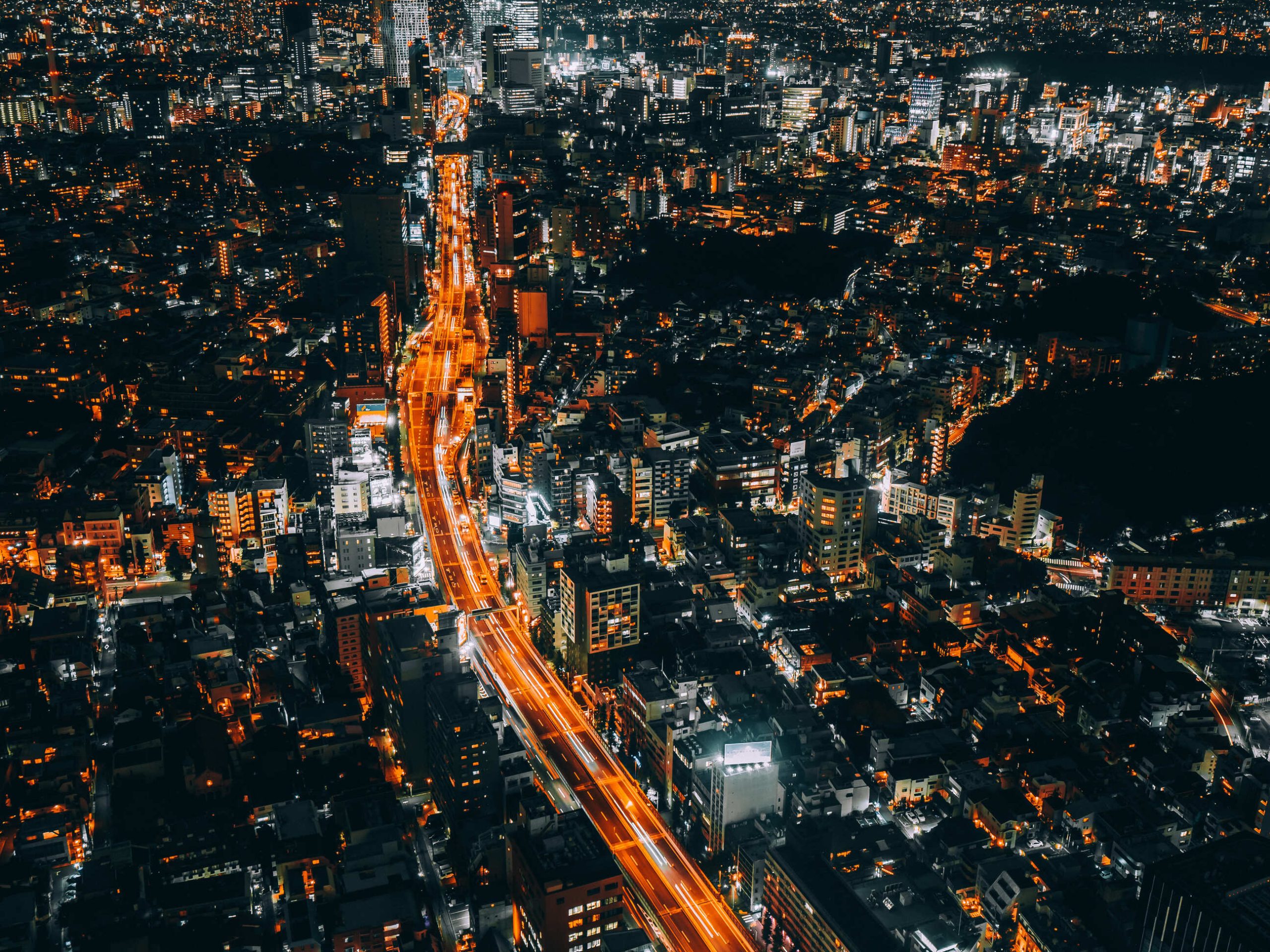 Vista aérea noturna de uma cidade iluminada, ilustrando o uso de dados e inteligência artificial na gestão das prefeituras.